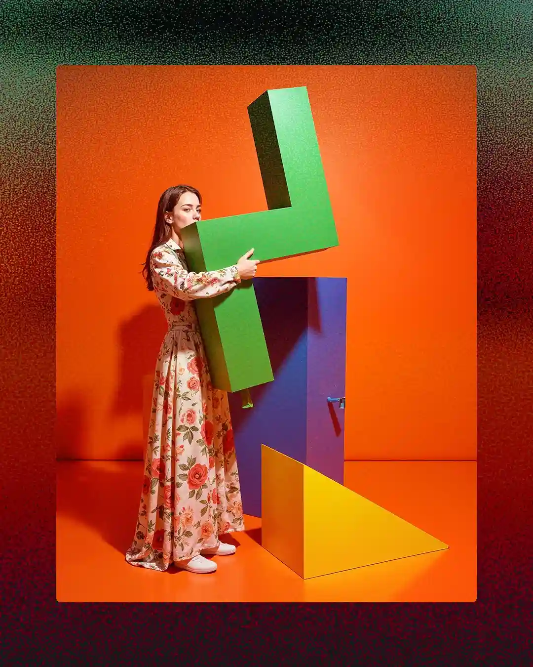 A woman in a colourful floral dress standing in front of vibrant orange, red and geometric abstract art shapes — editorial AI and data imagery